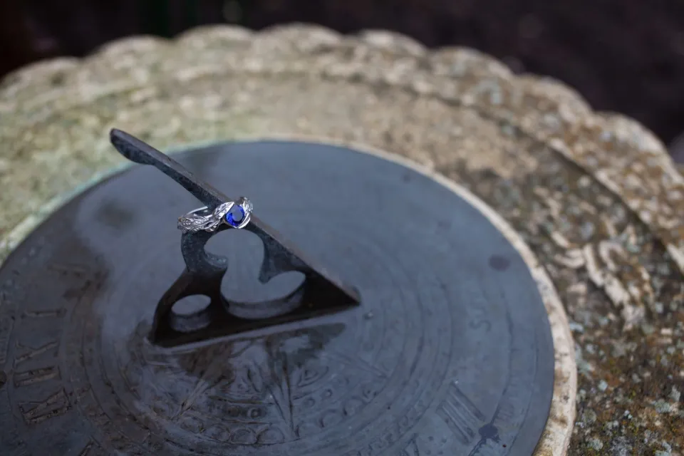 Verlobungsring mit blauem Stein auf einer Sonnenuhr
